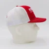 Red and white mesh trucker hat side view.
