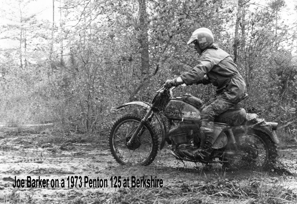 Motorcyclist riding a vintage dirt bike in mud