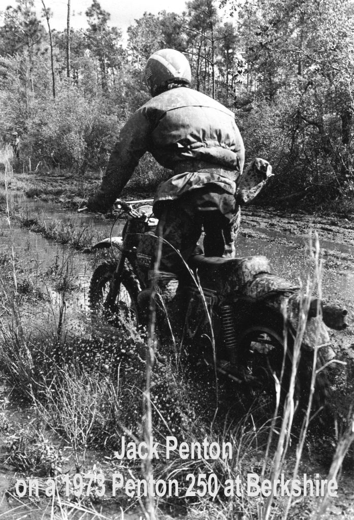 Rider on muddy trail with vintage motorcycle.