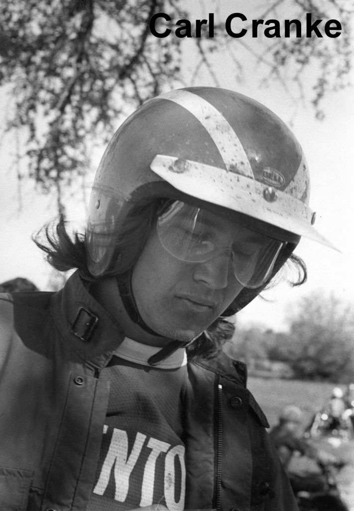 Motorcyclist wearing helmet and goggles outdoors.