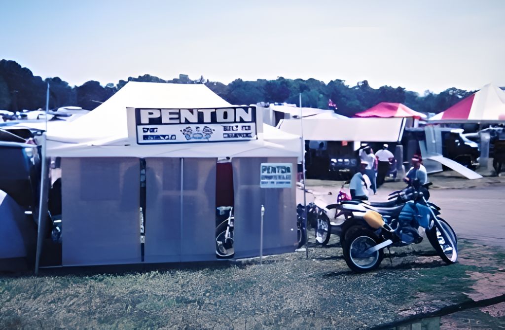 Motorcycle booth with tents at outdoor event.