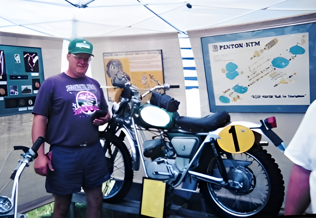 Man observes vintage motorcycle exhibition display.