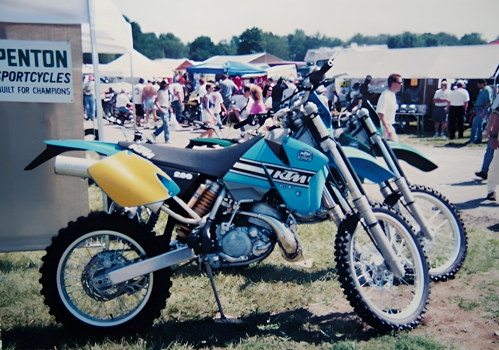 Vintage KTM motorcycles displayed at outdoor event.