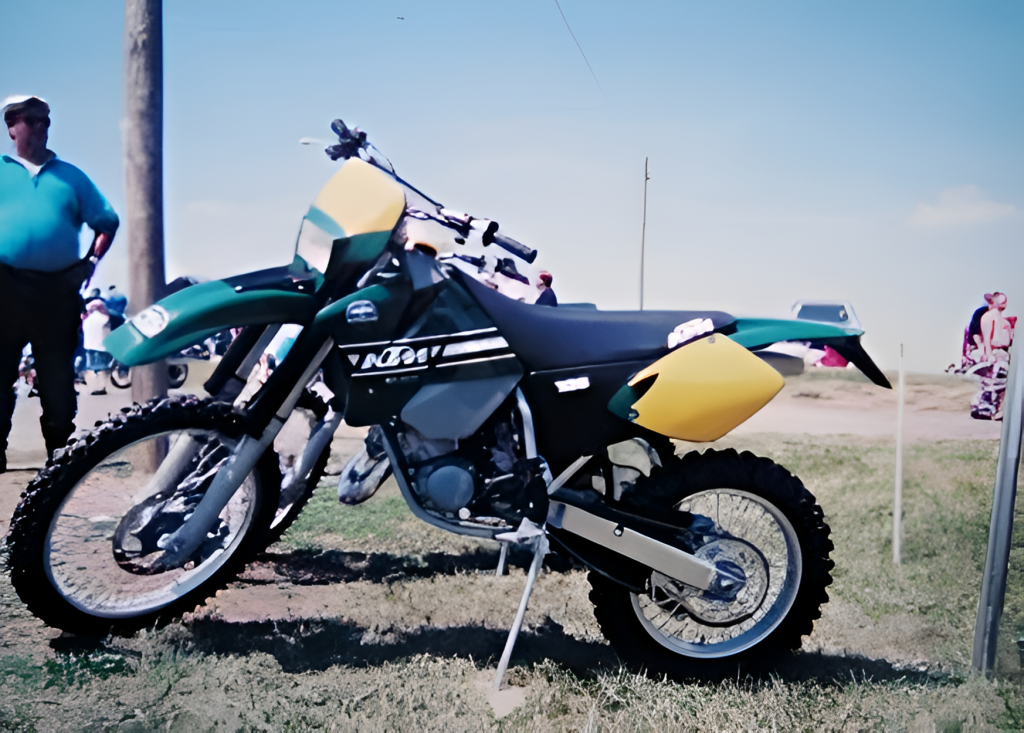 Green and yellow dirt bike on display outside.