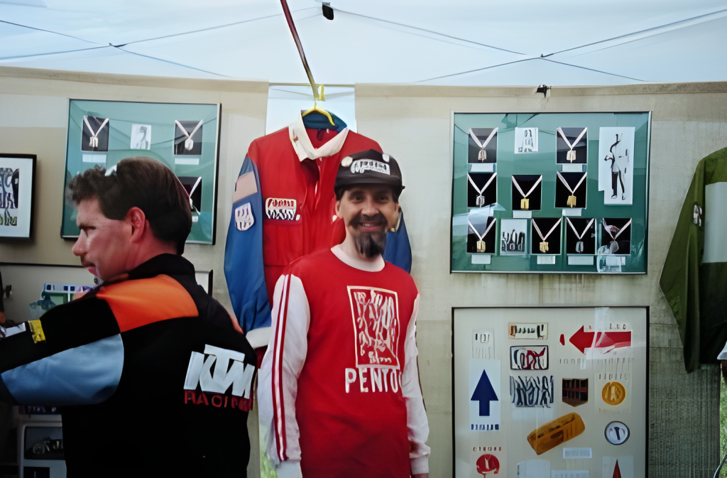 Motorcycle racing exhibit with jerseys and medals displayed.