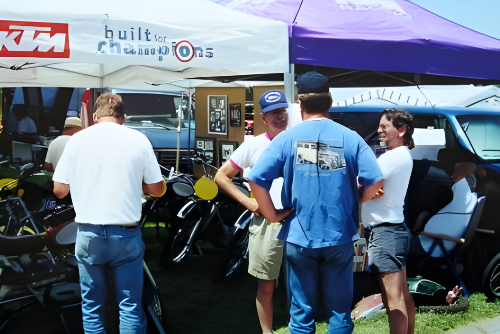 People talking at KTM motorcycle event tent