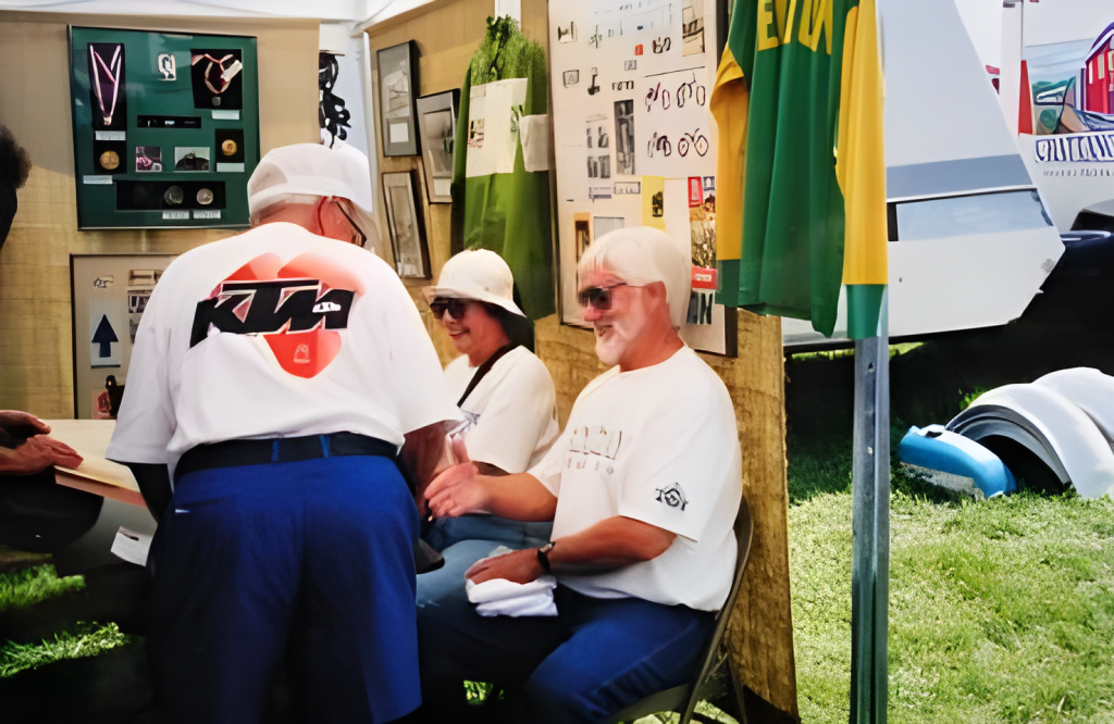 People talking at motorcycle event booth