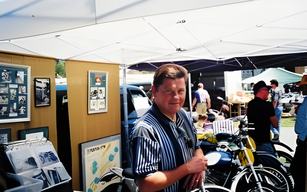 Man at outdoor art exhibit with bicycles.