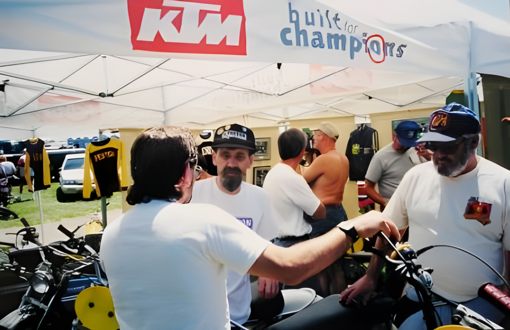 Group discussing at KTM event booth outdoors