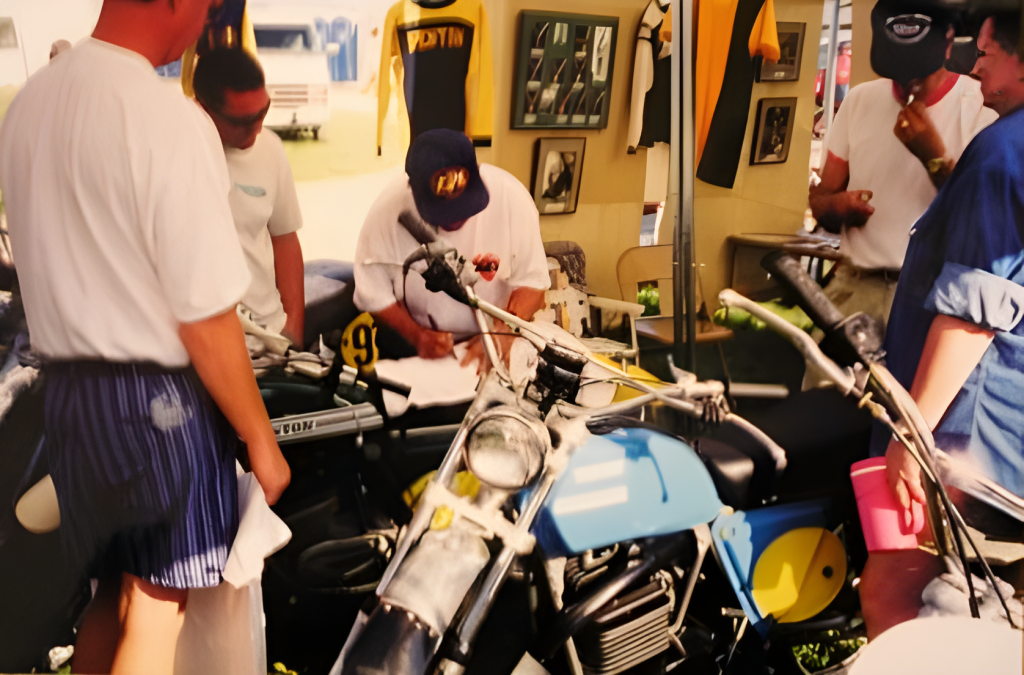 Men working on vintage motorcycle at event booth