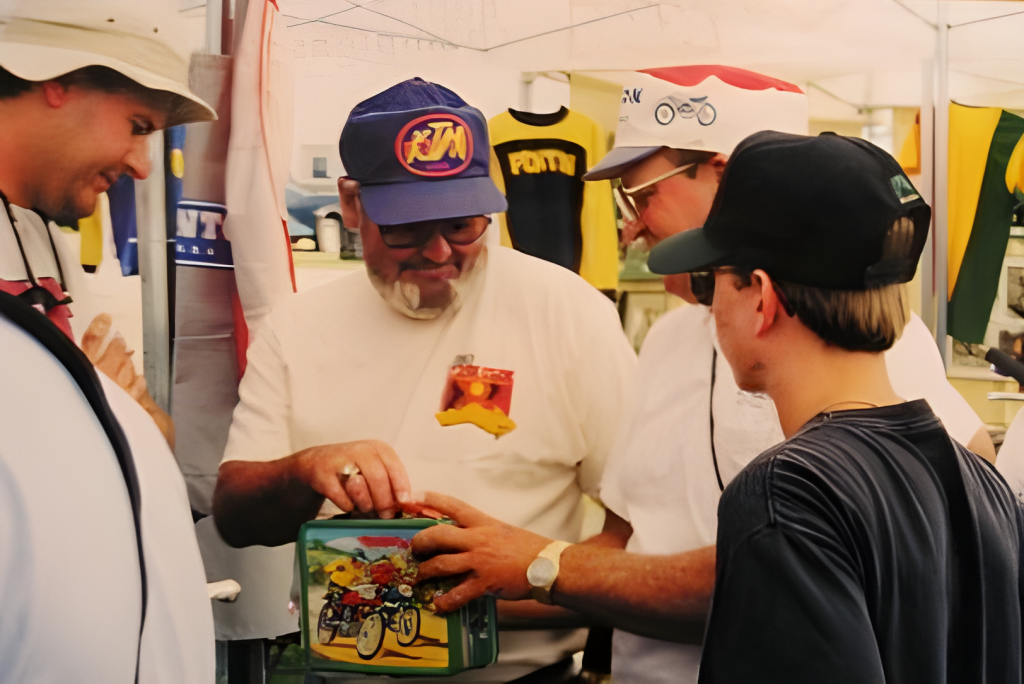 People examining vintage lunchbox at outdoor market