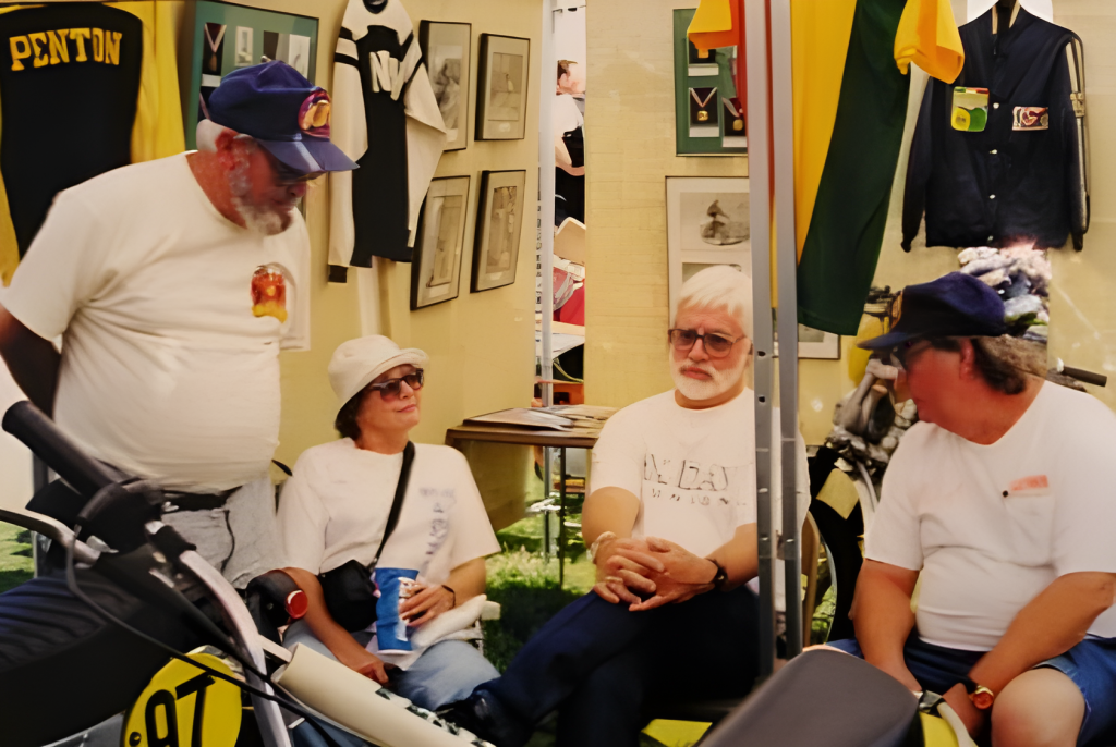 Group in vintage motorcycle exhibit booth