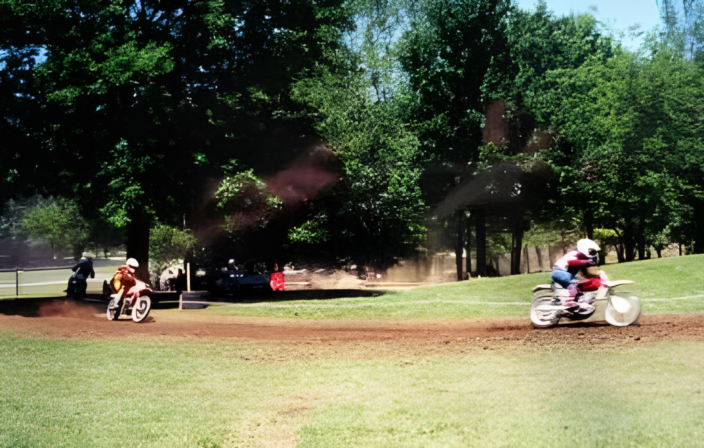 Motorcycle racers on a dirt track in a park.