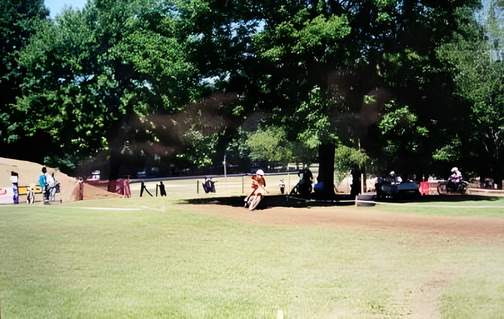 Motorcyclist riding on a dirt track in park.