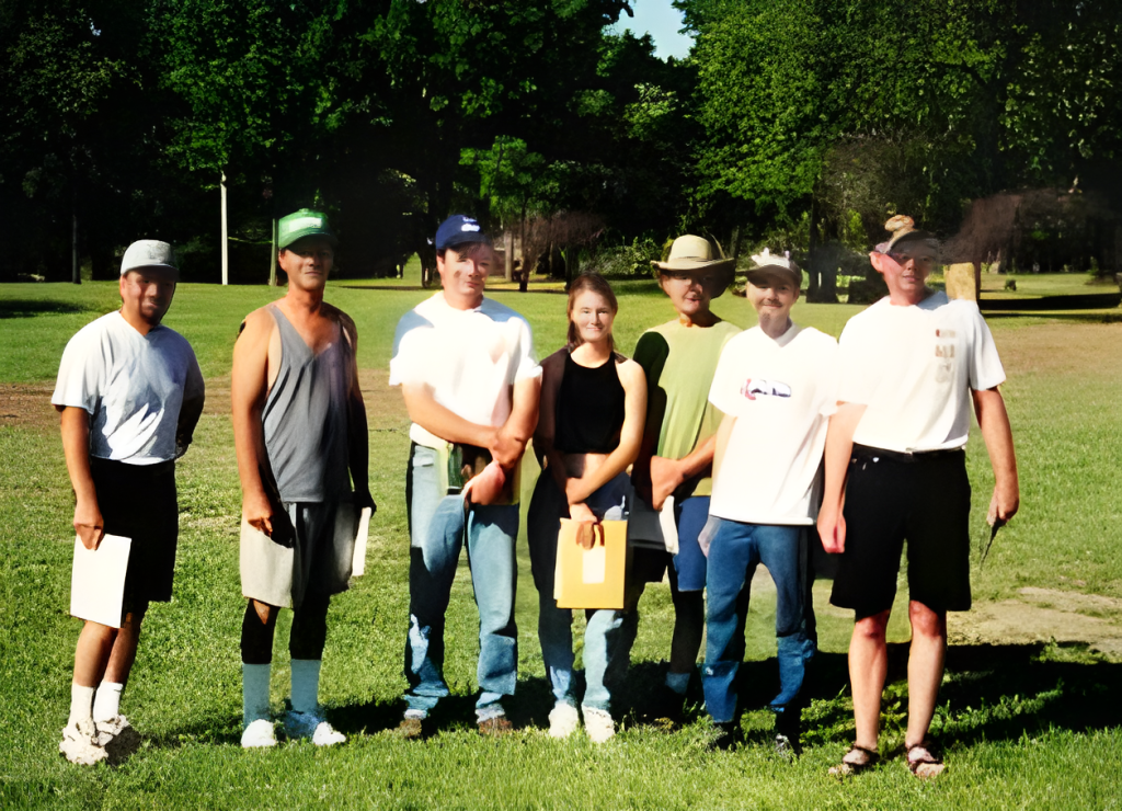 Group of people posing outdoors in a park.