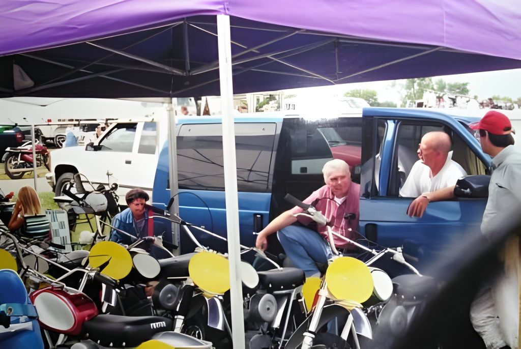 People discussing motorcycles under tent