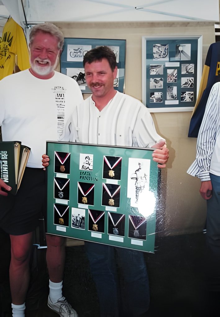 Two men holding framed medals display