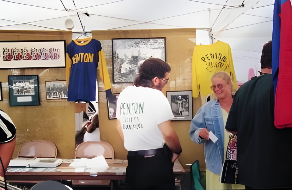 People at exhibition booth with vintage sports shirts.