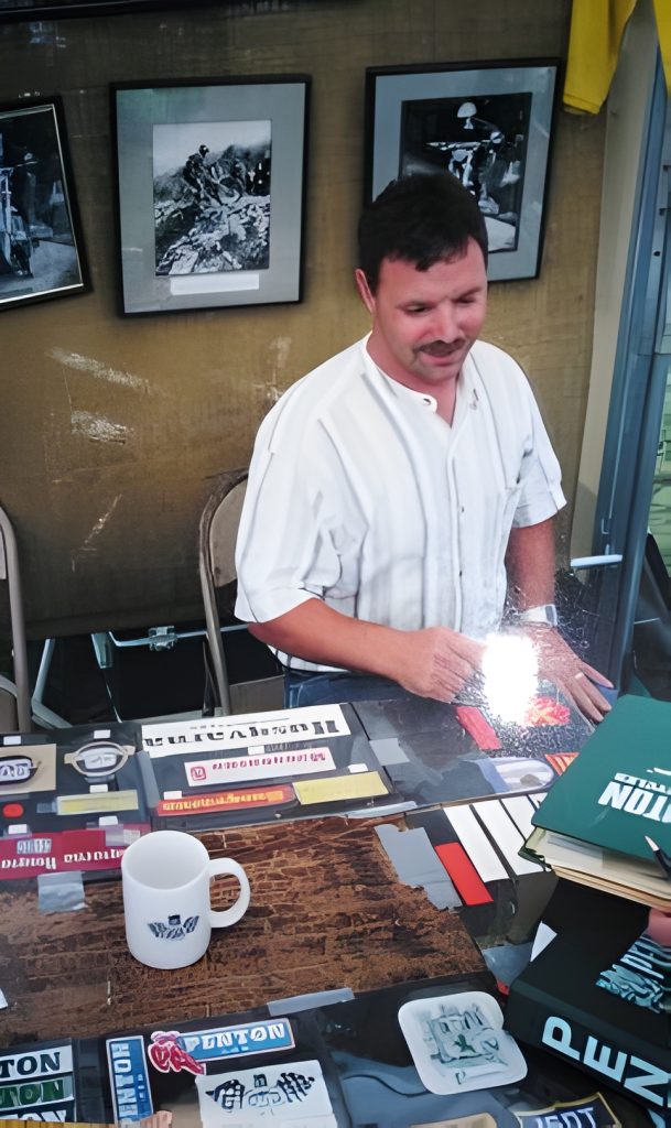 Man selling books at a market stall.