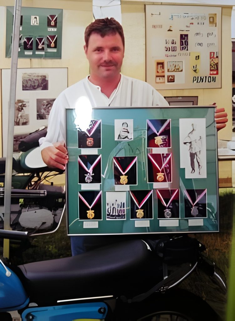 Man holding framed medals display at exhibit.