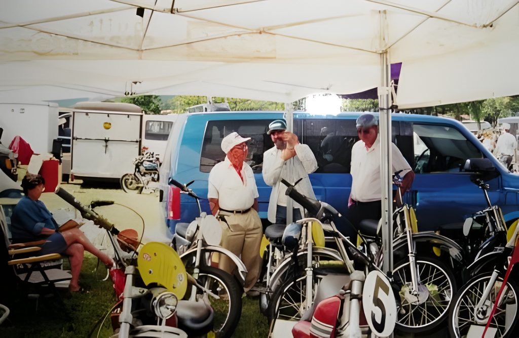 People at motorcycle event with blue van.