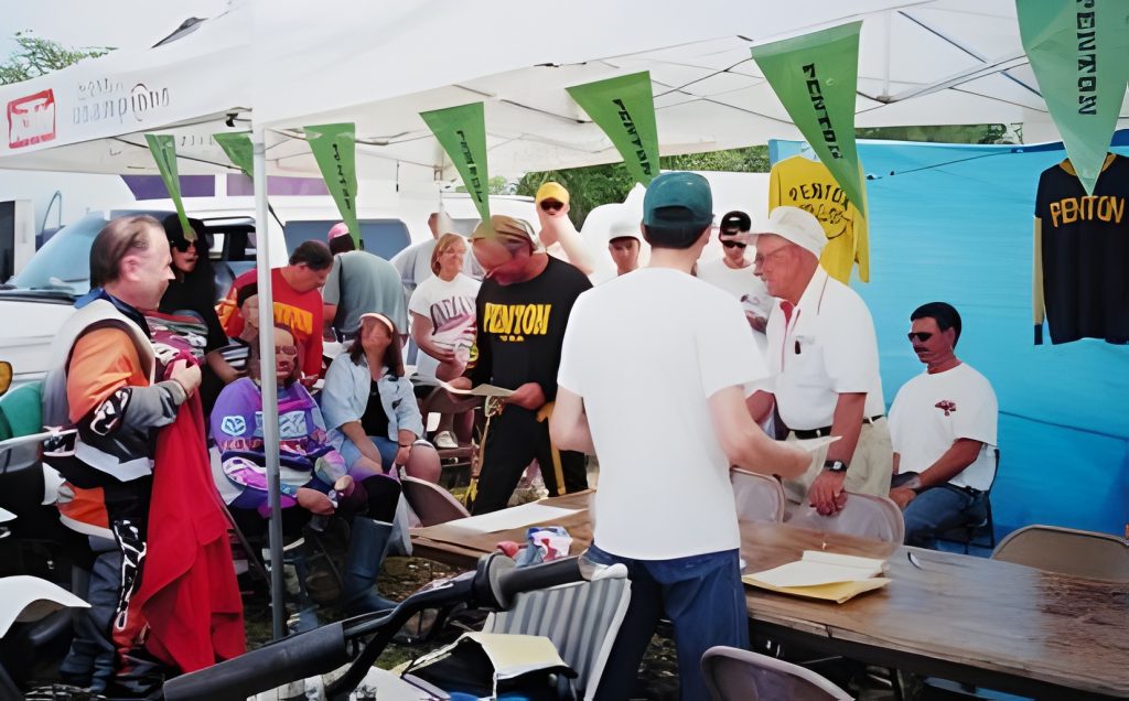 Group gathered under tent at outdoor event.