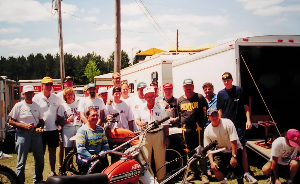 Group of people with motorcycles at outdoor event.