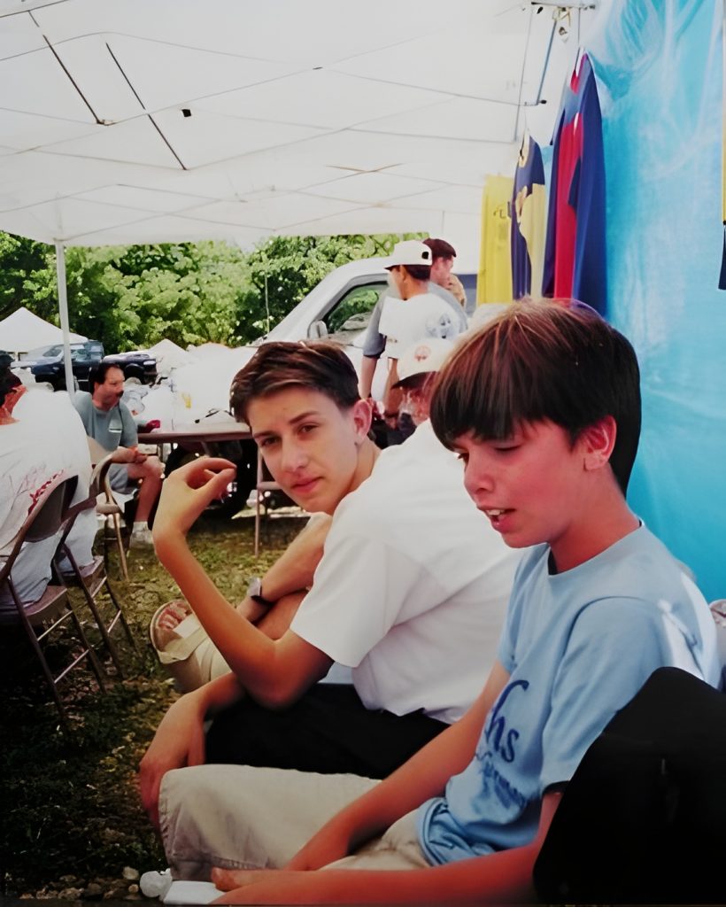 People relaxing under a tent at a fair.