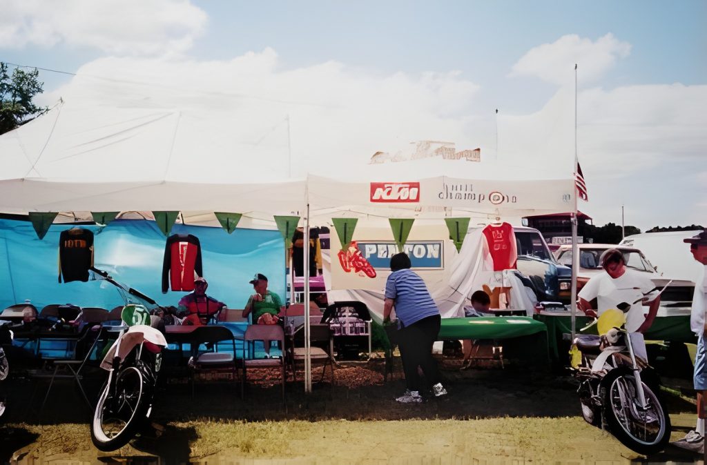 Outdoor market with motorcycles and merchandise display.