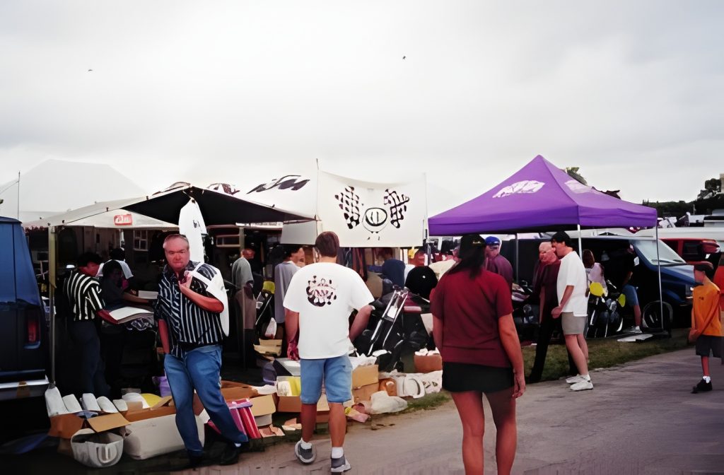 Outdoor market stalls with people shopping.