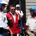 Smiling motorcyclists wearing helmets and gear