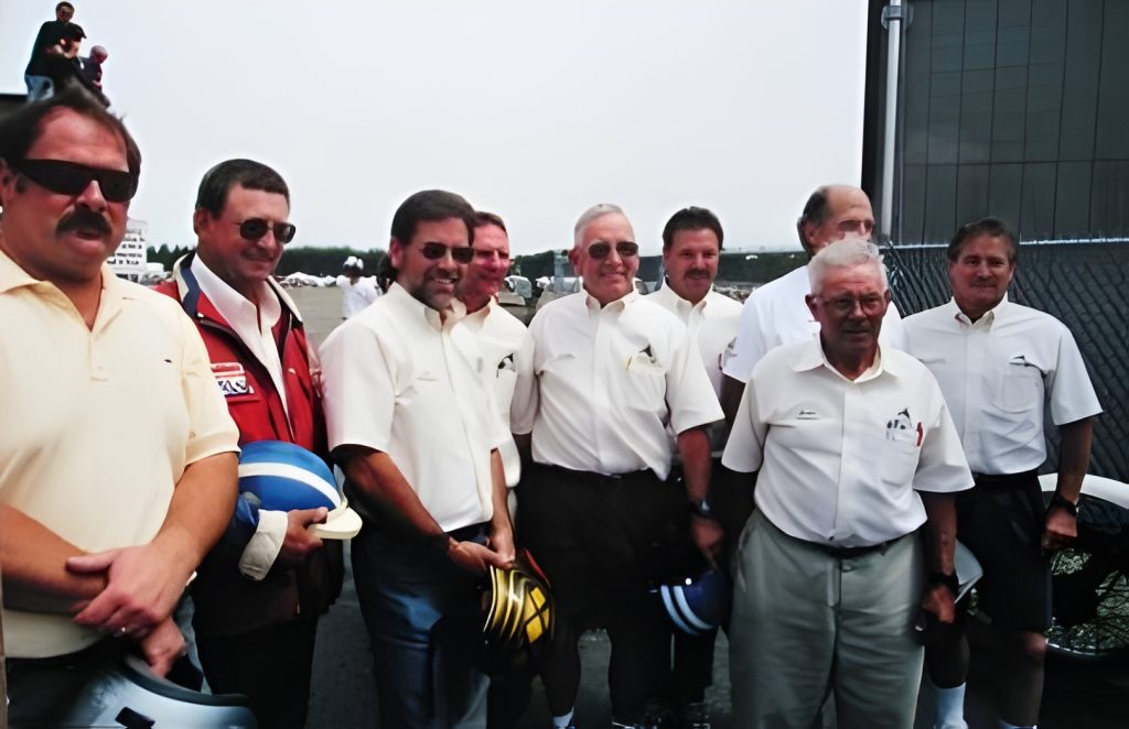 Group of men with helmets, posing together outdoors.