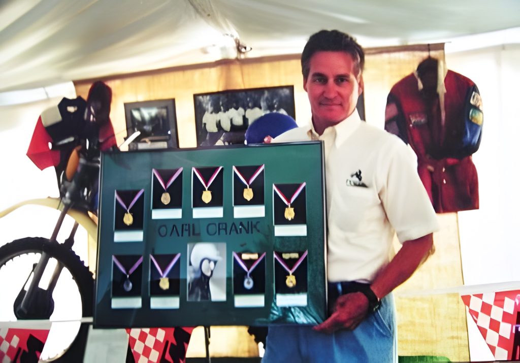 Man holding display with medals in a tent.