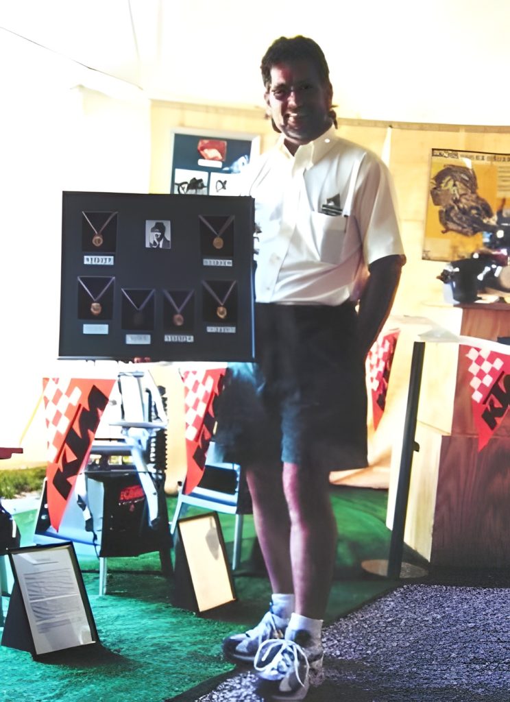 Person standing with display of medals.