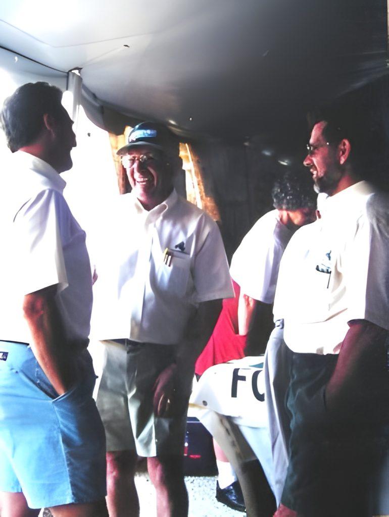 Group of men smiling and talking in tent