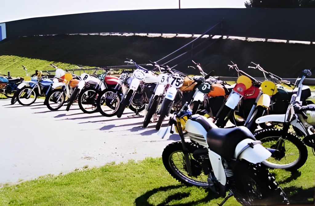 Vintage motorcycles parked in a row outdoors.