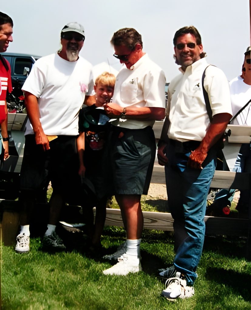 Group of people gathered outdoors, smiling.