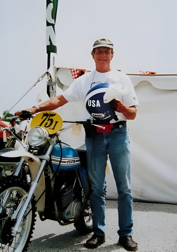 Person with motorcycle and USA helmet at event.