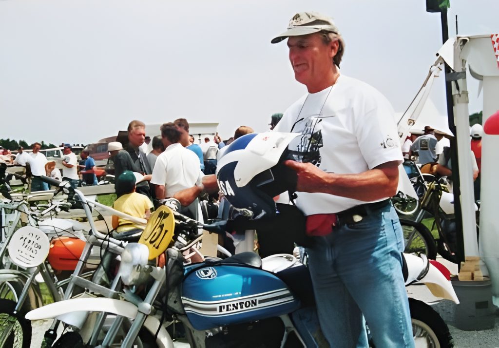 Man with vintage motorcycles at outdoor event.