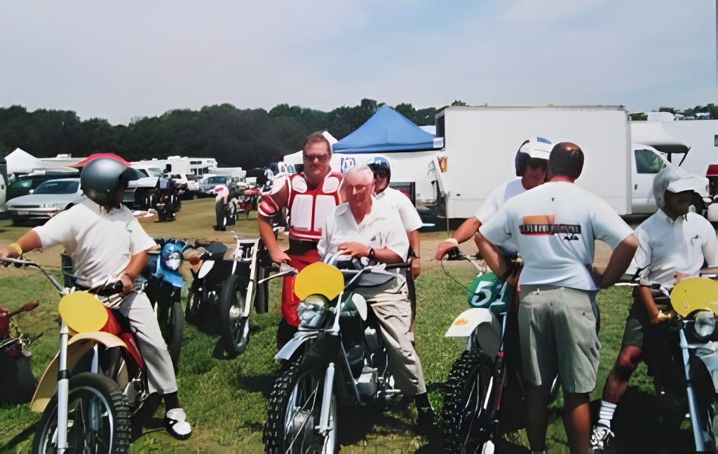 Group of people with motorcycles at outdoor event.