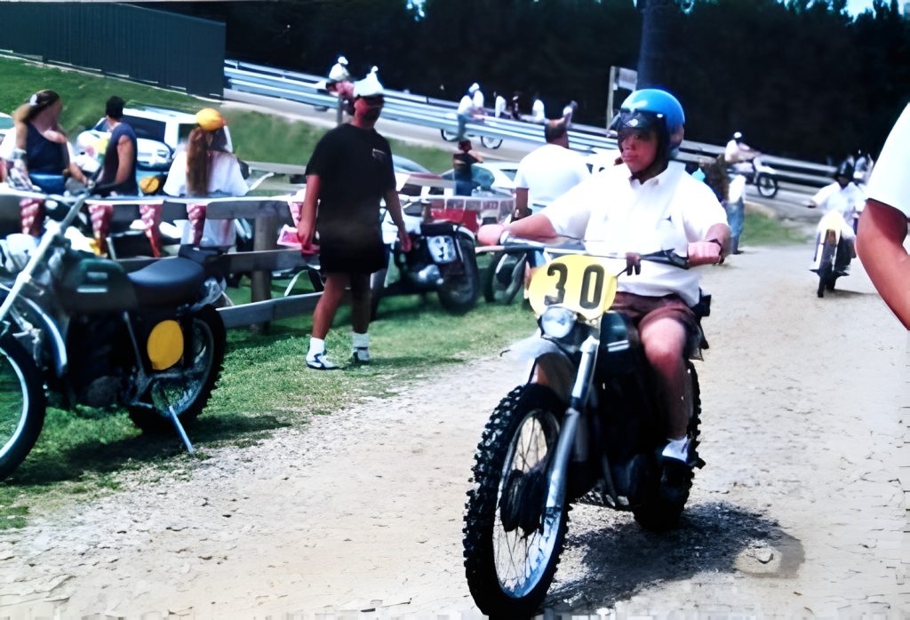 Person riding dirt bike number 30 at race event.