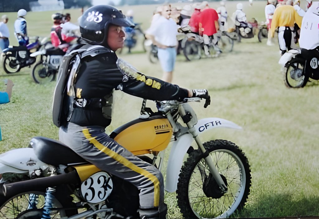 Motorcyclist preparing for a race on grass field.