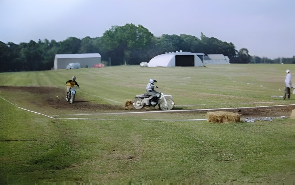 Motorcyclists racing on a grass track course.