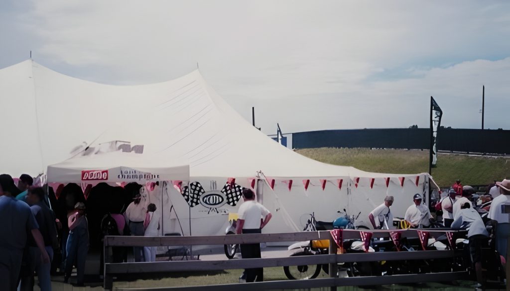 Event tent with people and motorcycles outside.