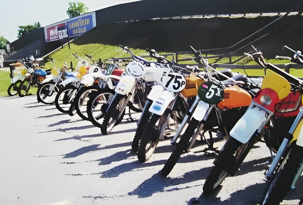 Vintage motocross bikes lined up at track