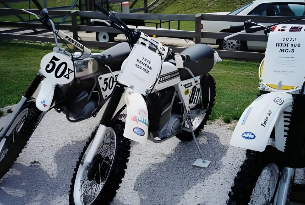 Three parked off-road motorcycles with number decals.