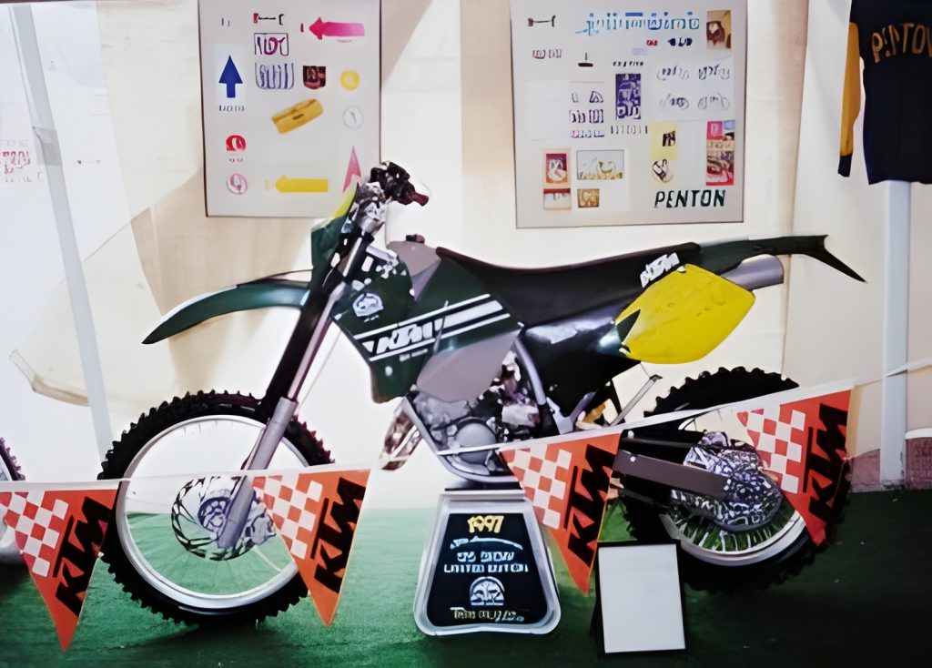 Vintage motorcycle display with KTM banners and posters.