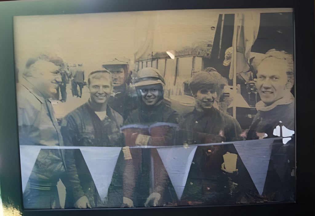 Smiling group photo with festive flag bunting.