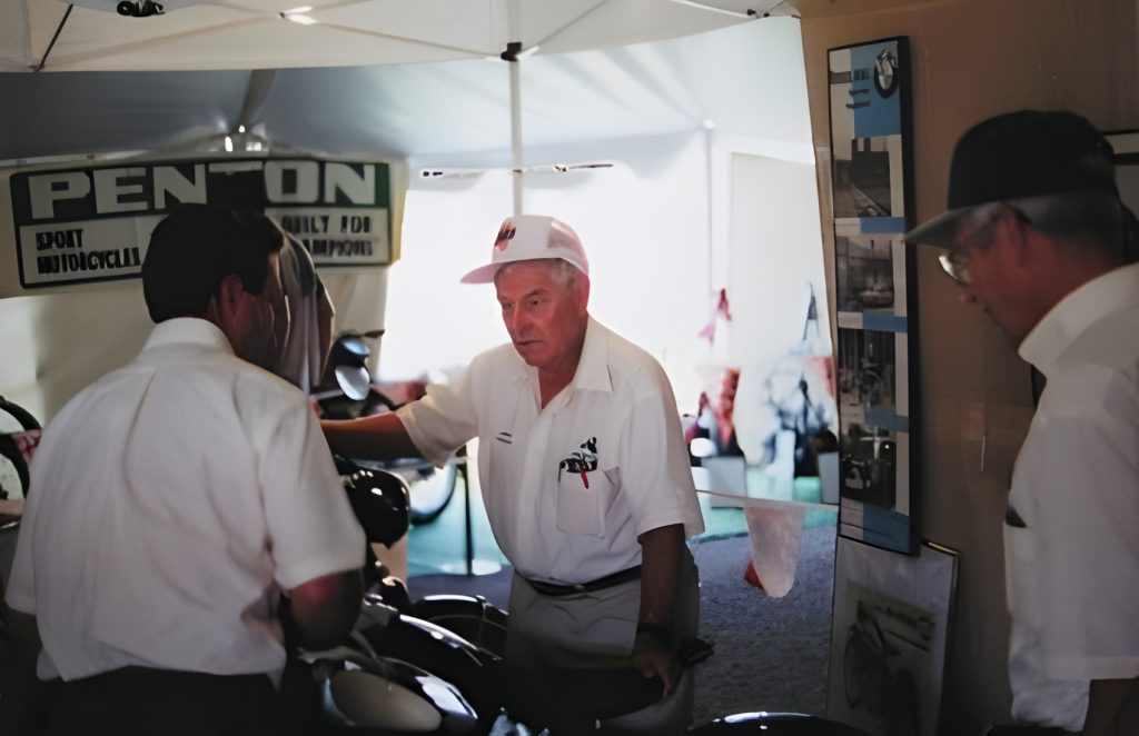 Men discussing motorcycles at Penton booth