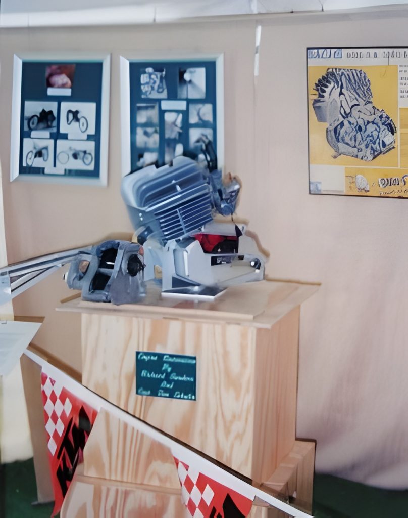 Exhibit featuring engine model on wooden podium.